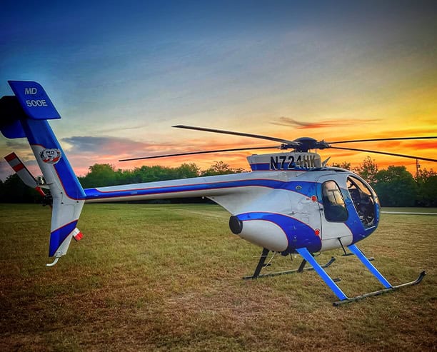 Blue White Helicopter On Field At Sunset