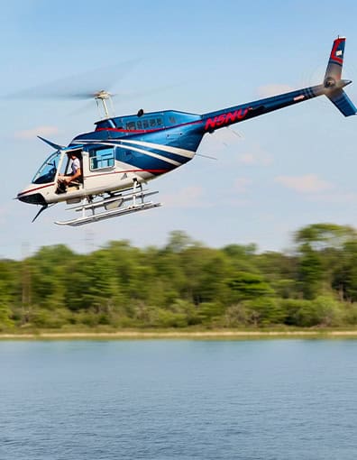 Blue White Utility Helicopter Flying Low Lake