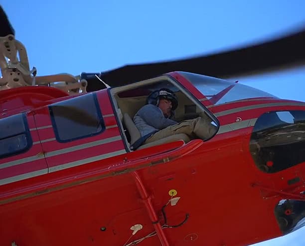 Red Helicopter Flying Over Forest