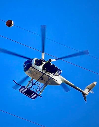 White Helicopter Performing Aerial Power Line Utility Work